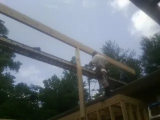 Carpenter setting a ridge beam over a new addition frame — Ice Dam Removal by Roofing Brothers in Vermilion