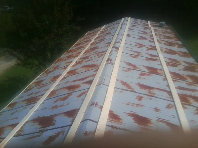 Rusted metal roof panels with new wood purlins before replacement — Storm Damage Roof Repair in Vermilion by Roofing Brothers
