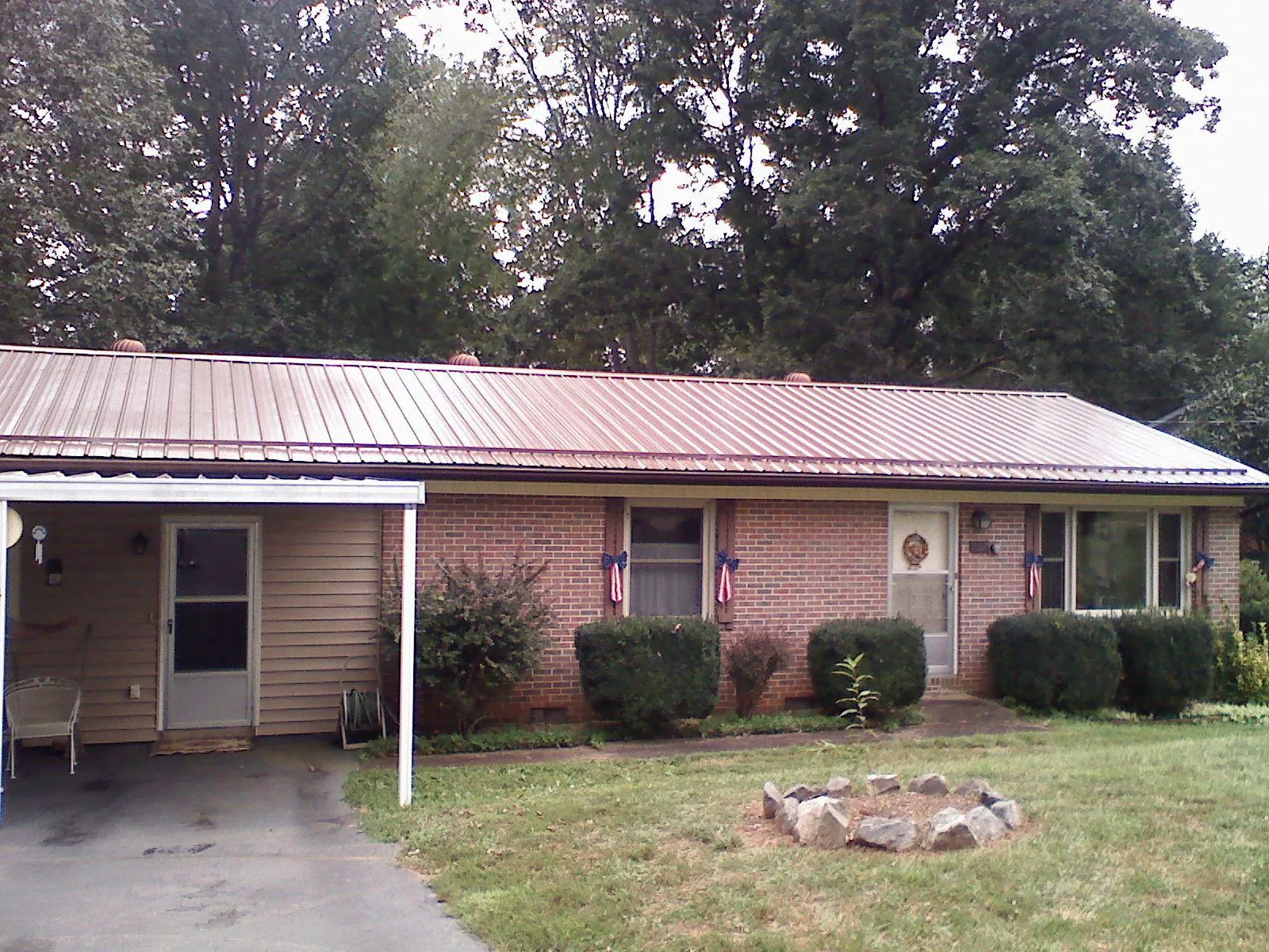 Bronze metal roof and carport on a brick ranch home — Roof Repair work by our crew in Vermilion